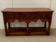 A George III style oak low dresser, moulded top over three frieze drawers (H77cm W138cm D46cm)