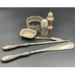 A collection of silver items to include, cruets, pin dish, silver handled shoehorn and button