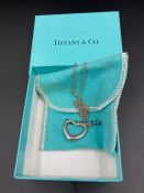 A Tiffany heart necklace on chain in original box.