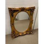A gilt framed wall mirror with scroll details (H106cm W85cm)