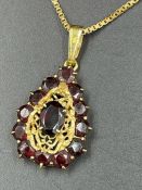 An 18ct gold chain and pendant inset with garnet (Total Weight 7.7g)