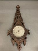 A Negretti and Zambra barometer in a carved oak case (W60cm)