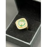 An 18ct gold ring set with diamonds and green stones