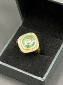An 18ct gold ring set with diamonds and green stones