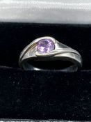 A silver fashion ring with amethyst style stone.