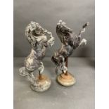A Pair of cast metal horses on stands