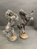 A Pair of cast metal horses on stands