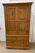 A pine double wardrobe with four drawers under (H194cm W105cm D52cm)