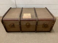 A wooden and metal bound travel trunk