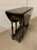 A drop sided small dining table on turned legs