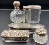 A selection of six silver topped glass dressing table pots