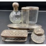 A selection of six silver topped glass dressing table pots