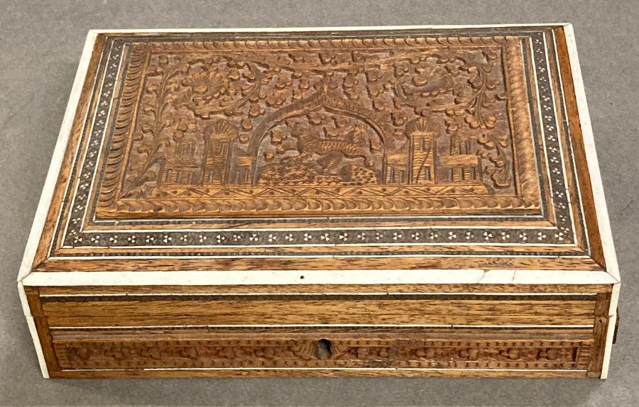 A carved box, decorative with an Indian theme