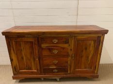 A hardwood sideboard with drawers to centre, flanked by cupboards (H88cm W150cm D45cm)