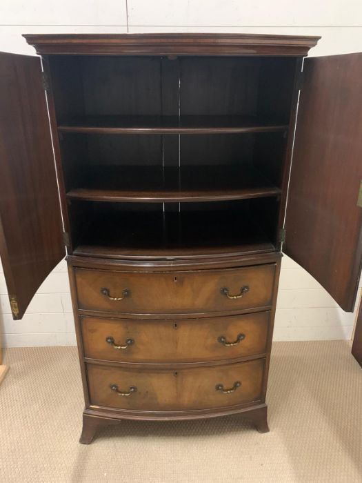 A mahogany bow fronted cupboard with double doors opening to shelves and three drawers below (H153cm - Image 2 of 3