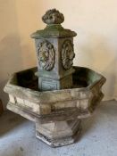 An octagon tiered fountain with centre section cast with lion masks on fluted octagon base (H140cm