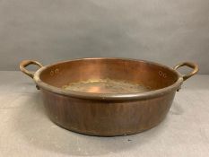 A large copper pan by Maple and Co London (51cm handle to handle)