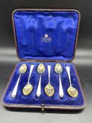 A cased set of silver and enamel coffee spoons.