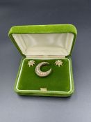A gold and seed pearl earring and brooch set in the shape of a crescent moon and star earrings.