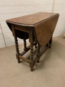 An oak drop sided dining table on barley twist legs (H73cm W90cm)