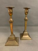 A pair of 19th Century brass candlesticks with engraved shafts and square bases