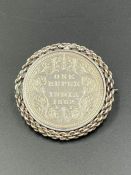 A silver brooch with an 1862 Indian One Rupee coin mounted