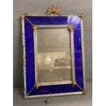 A glass wall mirror with cobalt blue boarder and twisted glass rods finished to each corner with