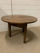 An oak circular side table on a triform base and legs