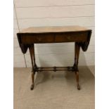 A regency style sofa table with two drawers to front supported on columns with turned stretcher on