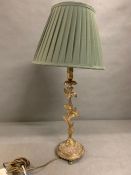 A brass table lamp with centre stem floral foliage on out swept legs