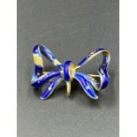 An 18ct gold and enamel bow brooch, some wear to the enamel. (Total Weight 6.7g)