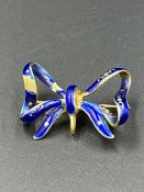 An 18ct gold and enamel bow brooch, some wear to the enamel. (Total Weight 6.7g)