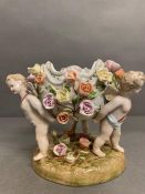 A Meissen centrepiece or fruit bowl with floral decoration supported by three cherubs