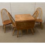 A blonde Ercol dining table and four chairs