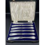 A Boxed set of of silver handled butter knives, hallmarked for Sheffield 1935 by John Biggin