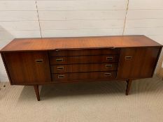 A Mid Century sideboard with drawers to centre, flanked by cupboards (H78cm W183cm D45cm)