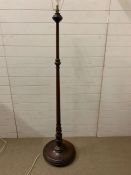 A mahogany stand lamp with turned centre support on circular base