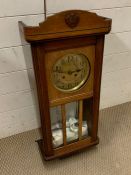 An oak case wall clock with brass face
