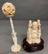 An ivory Buddha and a puzzle ball on stand.