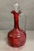 An 19th Century ruby glass wine jug with inner moulded panels, flared rim with pinched lip, tall
