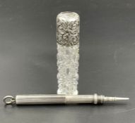 A silver pen and a silver topped scent bottle