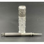 A silver pen and a silver topped scent bottle