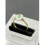 An 18ct gold emerald and diamond daisy ring