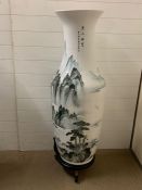 A large floor standing porcelain vase on stand with a waterfall theme white and green