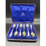 A cased set of silver and enamel coffee spoons.