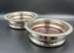 A pair of silver plated wine coasters