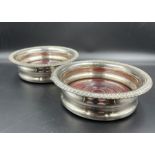 A pair of silver plated wine coasters