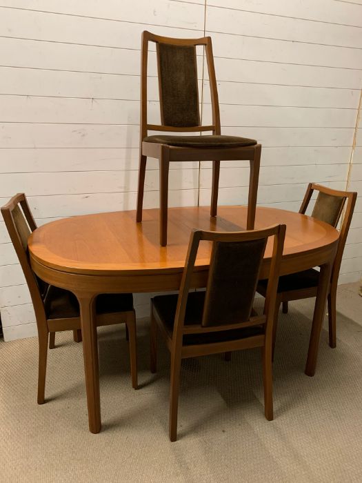 A Mid Century dining table with centre leaf and four chairs by Nathan