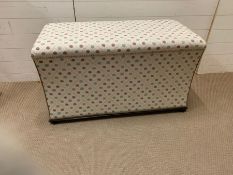 An ottoman with stud detail and mahogany base frame opening to storage (H1cm W105cm D49cm)