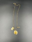 A 9ct gold necklace with three pendants including a St Christopher (Total weight 10.3g)